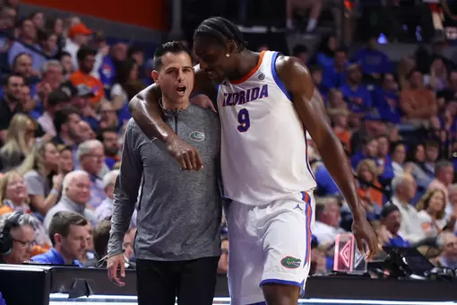 Rueben Chinyelu puts his arm around Todd Golden as he walks off the court.