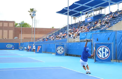 Jeremy Jin tossing the tennis ball up for a serve in singles on court five.