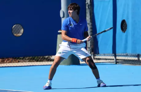 Andreas Timini waiting on the baseline for a serve in doubles against FGCU.