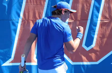 Francesco Cordova fist pumping with his back turned from the camera to celebrate a point in singles.