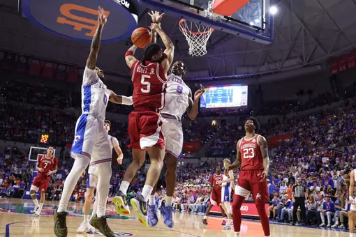 Rueben Chinyelu and Boogie Fland jump to defend a shot from Arkansas' Darius Acuff.