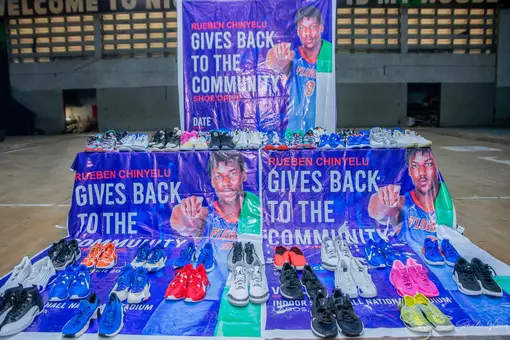 Shoes sent back to Nigeria by Rueben Chinyelu are displayed with signs that say "Rueben Chinyelu gives back to the Community."