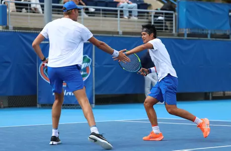 Henry Jefferson and Tanapatt Nirundorn high fiving each other following a point in doubles against Oklahoma on court one.
