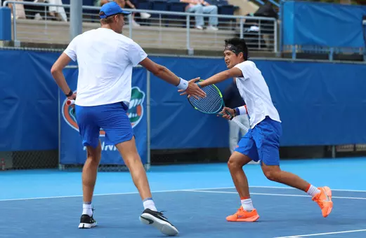 Henry Jefferson and Tanapatt Nirundorn high fiving each other following a point in doubles against Oklahoma on court one.