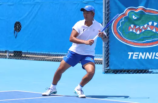 Jeremy Jin in motion to hit a ball on the baseline of the tennis court in singles against LSU.