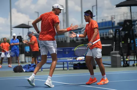 Henry Jefferson (left) and Tanapatt Nirundorn (right) high fiving each other on court one following a point in doubles on court one against Stetson in NCAA First Round.