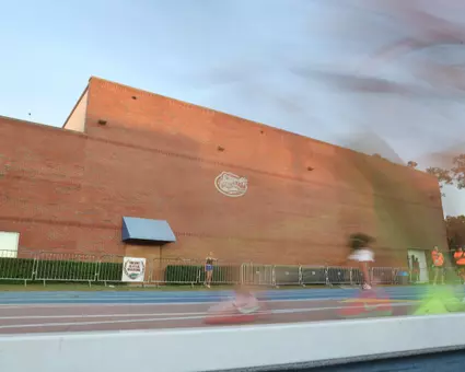Sunlight hits a brick building with a silver Gators logo