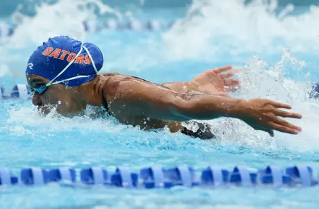 Beatriz Bezerra taking a breath while swimming fly in a home meet in the 2025-26 season.