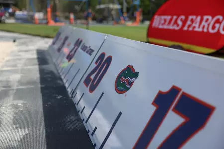 A Florida Gators logo on a white measuring board in a sand pit.