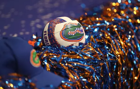 A volleyball with the Florida Gators logos sits in between orange and blue pompoms.