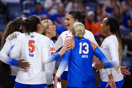 Florida volleyball in white jerseys celebrates