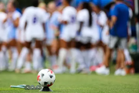 Soccer ball on tee with Gator soccer team in background 260805