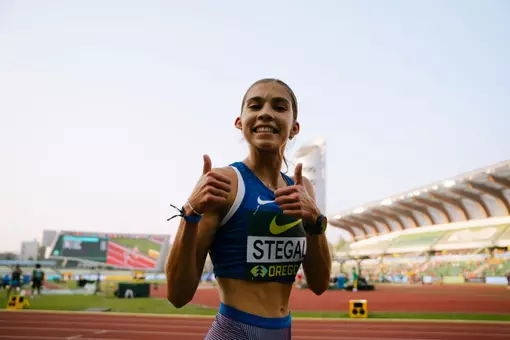 A female athlete gives a thumbs up in USA track & field jersey