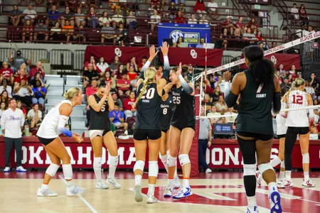 A volleyball team in black Florida jerseys celebrates a point