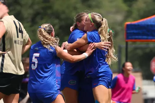 Mia Gray (#5) and Zoe Main (with green pre-wrap in hair) celebrate with Tatum Borman after her tying goal Sunday versus No. 5 Wake Forest.