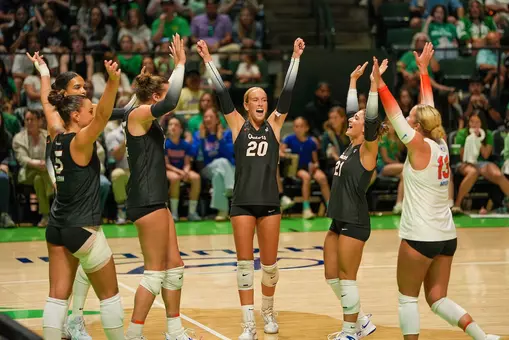 A group of female athletes in black Florida jerseys celebrate