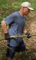 Georgia swimming and diving head coach Jack Bauerle helps clean part of Memorial Park on Monday.