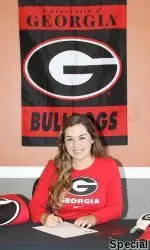 Gaby Coello inks her scholarship papers with Georgia.