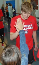 Swimmer Nic Fink greets students at last year's Learn, Play, Excel event.