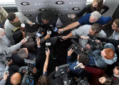 Surrounded by microphones and cameras, Sony Michel speaks to the media Monday.