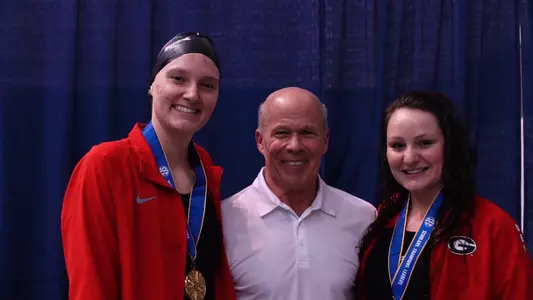 Tom Cousins Head Coach Jack Bauerle celebrates with breaststroke medalists Zoie Hartman and Danielle Della Torre.