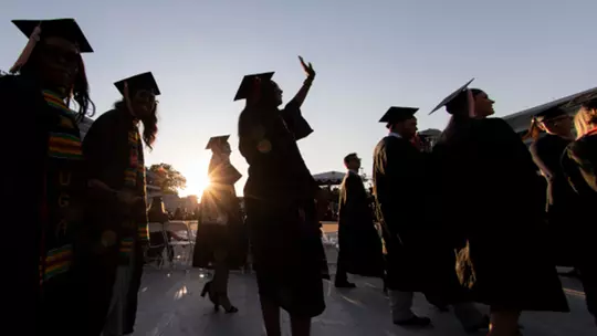 Graduates celebrate while walking in during the processional during the Spring Undergraduate Commencement Ceremony in Sanford Stadium.