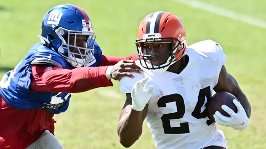 Giants linebacker Lorenzo Carter (59) chases Browns running back Nick Chubb (24) during a joint practice.