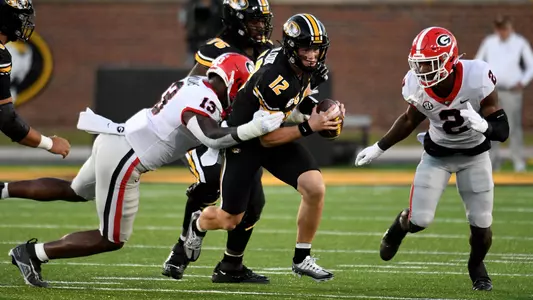 Missouri quarterback Brady Cook (12) runs with the ball as Georgia defensive lineman Mikel Williams (13) and defensive back Smael Mondon Jr. (2) defendduring the first half of an NCAA college football game Saturday, Oct. 1, 2022, in Columbia, Mo. (AP Photo/L.G. Patterson)