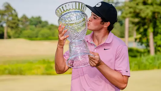 Davis Thompson kisses the trophy after winning the Korn Ferry Tour REX Hospital Open on Sunday.