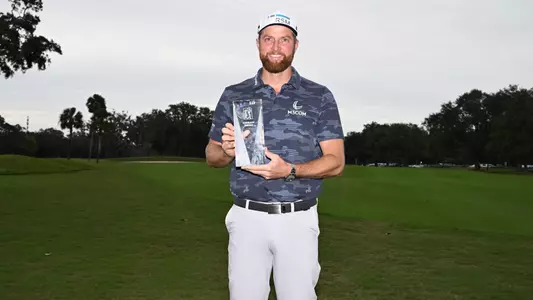Chris Kirk posing with the PGA TOUR Courage Award.