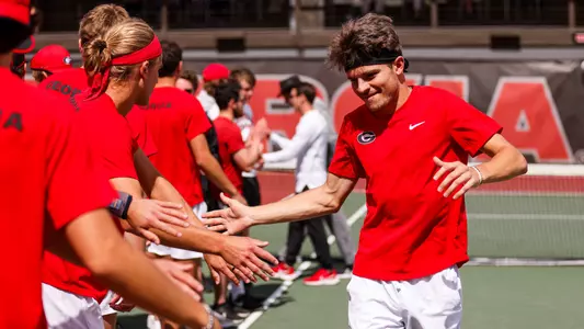 Britton Johnston high fiving teammates before the team's match against Vanderbilt.