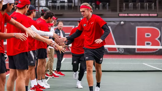 Philip Henning giving high-fives to his teammates before taking on Louisville in the ITA Kickoff in January of 2023.