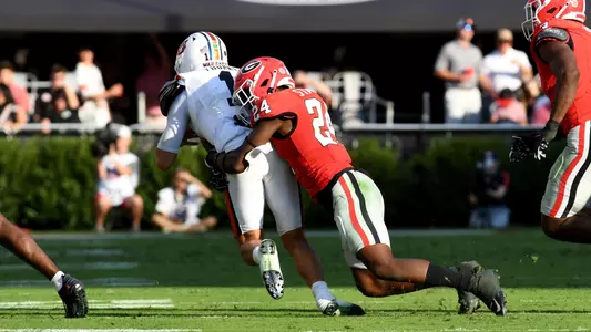 Malaki Starks #24 of the Georgia Bulldogs tackles Payton Thorne #1 of the Auburn Tigers