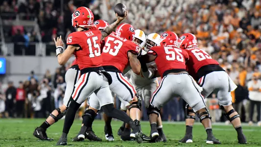Carson Beck #15 of the Georgia Bulldogs passes the ball while protected by Dylan Fairchild #53, Jared Wilson #55, and Tate Ratledge #69 of the Georgia Bulldogs