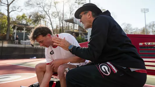 Coach Diaz going through strategy with Freshman Freddy Blaydes during the team's match against Texas A&M in the ITA Kickoff Athens Regional final.