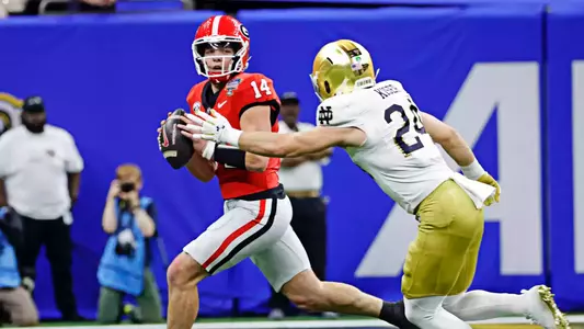 Jan 2, 2025; New Orleans, LA, USA; Georgia Bulldogs quarterback Gunner Stockton (14) controls the ball during the first quarter against Notre Dame Fighting Irish linebacker Jack Kiser (24) at Caesars Superdome. Mandatory Credit: Amber Searls-Imagn Images