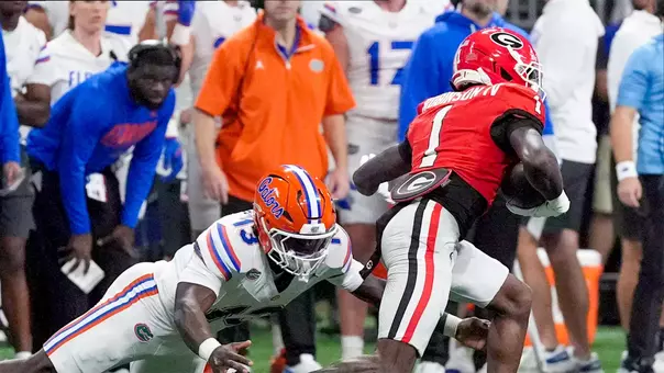 Oct 31, 2026; Atlanta, Georgia, USA; Florida Gators running back Jadan Baugh (13) attempts to tackle Georgia Bulldogs defensive back Ellis Robinson IV (1) after his interception during the first half at Mercedes-Benz Stadium. Mandatory Credit: Dale Zanine-Imagn Images