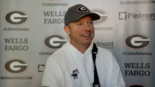 Coach Mike White in front of backdrop