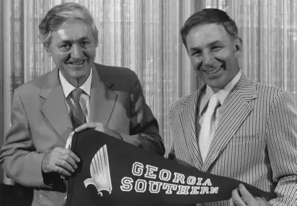 Former Eagles head coach Jack Stallings (right) and former Georgia Southern College President Gregory Pope (right) hold a pennant with the old GSC Eagle logo at Stallings' introductory press conference in May 1975.