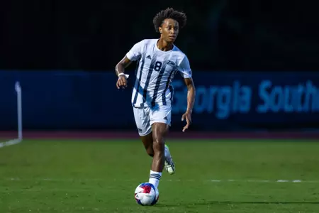 Georgia Southern men's soccer player Kevin Pierre (8) dribbled a ball upfield in an NCAA match against the Jacksonville Dolphins.