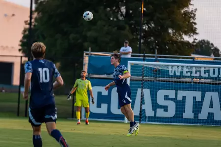 Toby Nevile heading a ball in a match against Coastal Carolina