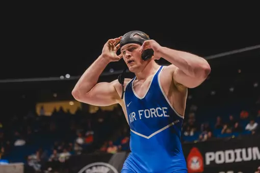 Rylan Kuhn removes his head gear after winning a match at the Big 12 Championships