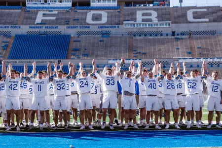 Air Force lacrosse raises their hands in victory after the playing of the third verse.