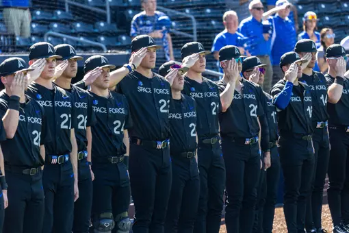 Air Force baseball salutes during the national anthem wearing their Space Force uniforms.