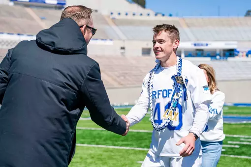 Nolan Parlette shakes the Athletic Director's hand at the senior day ceremony