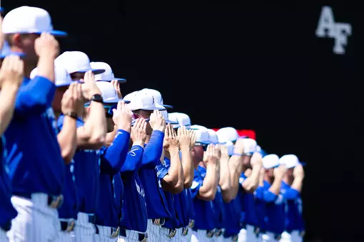 The baseball team salutes for the national anthem during pregame at Erdle Field