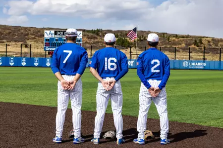 From left to right: Dawson Thrush, Ben Niednagel, and T.J. Oster stand at attention before the national anthem at Erdle Field