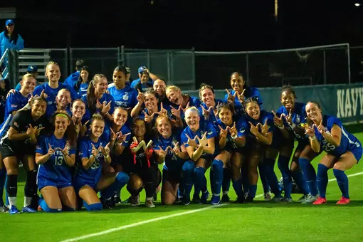 Women's soccer team poses for a group shot after beating Navy