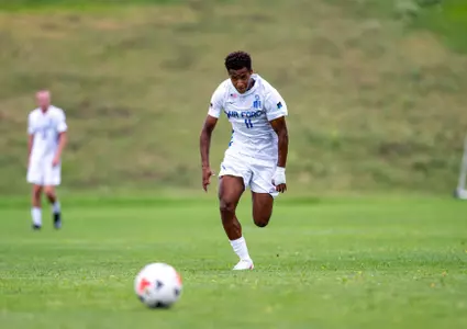 Menes Ajyemen dribbles the ball down the pitch in full stride.