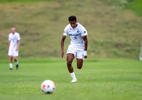 Menes Ajyemen dribbles the ball down the pitch in full stride.